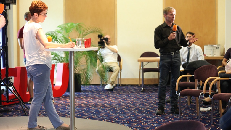 Das Bild zeigt ein Mitglied in Chemnitz bei seiner Frage an die CDU-Generalsekretärin.