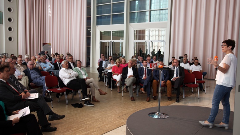 Auf dem Foto sieht man mit Blick von hinten über die Bühne ins Publikum: CDU-Generalsekretärin Annegret Kramp-Karrenbauer hört den CDU-Mitgliedern zu.