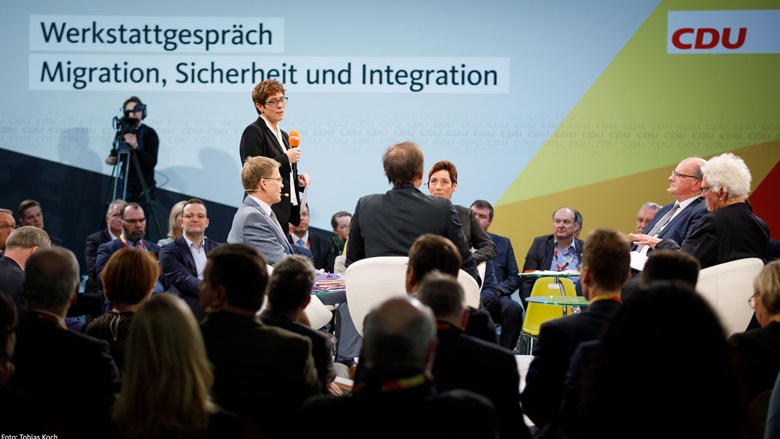 Annegret Kramp-Karrenbauer begrüßte die Podiumsteilnehmer und Gäste vom Rundpodium aus freisprechend mit Handmikrofon. Annegret Kramp-Karrenbauer begrüßte die Podiumsteilnehmer und Gäste vom Rundpodium aus freisprechend mit Handmikrofon.